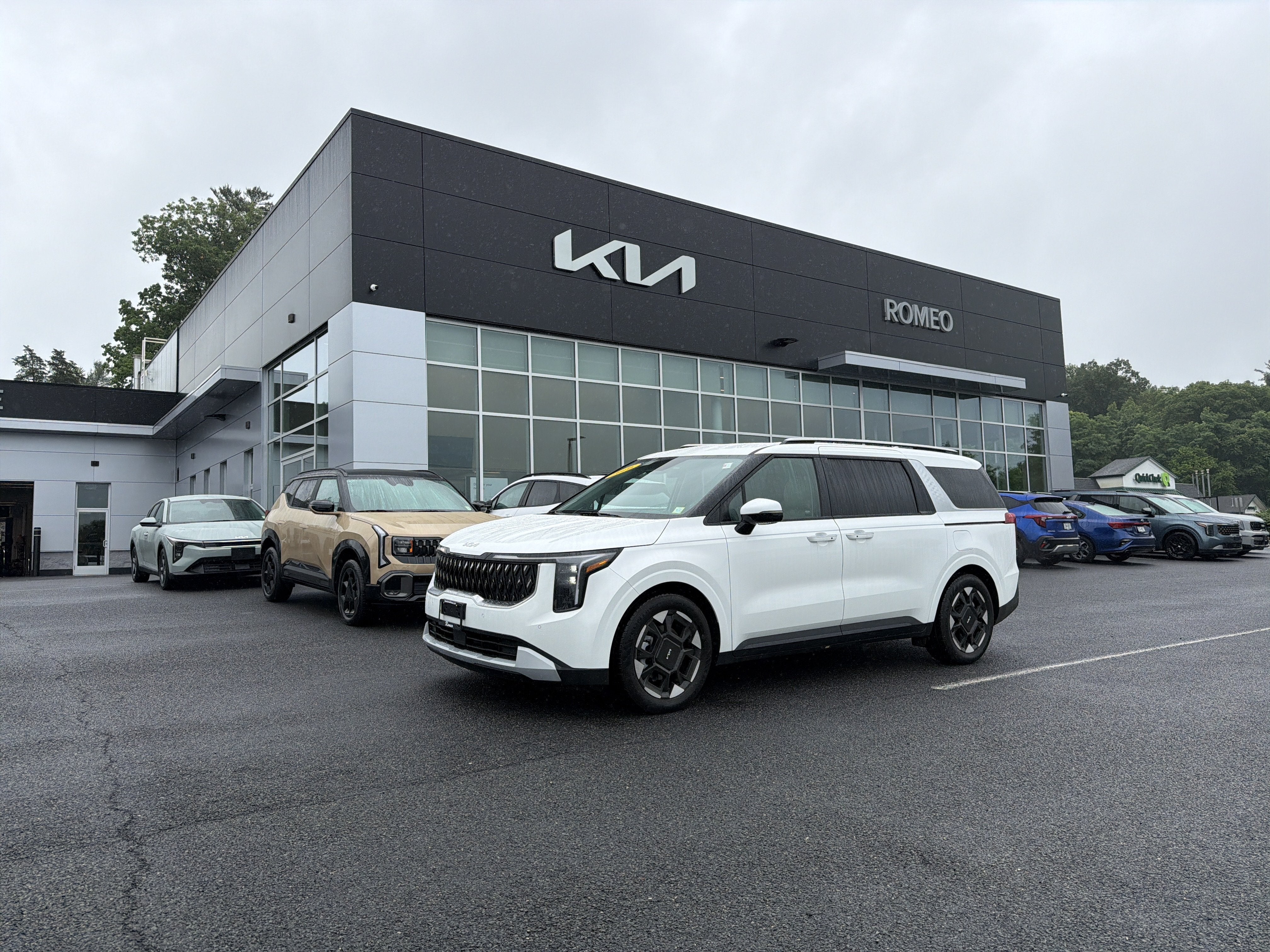 2026 Kia Carnival EX in Snow White Pearl — front three-quarter view